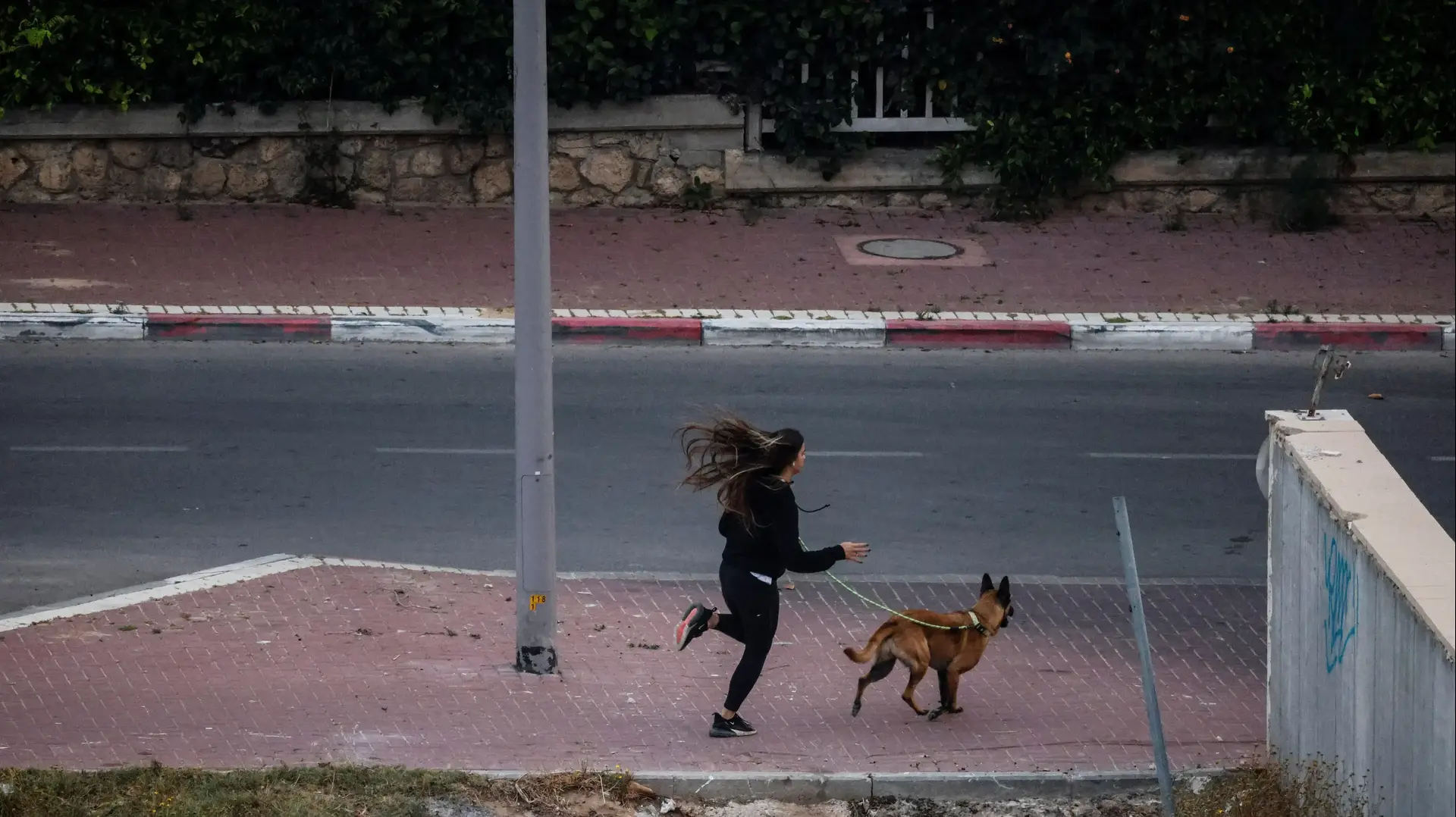 אישה רצה באזעקת צבע אדום באשקלון. 12 במאי 2023 אישה רצה באזעקת צבע אדום באשקלון. 12 במאי 2023