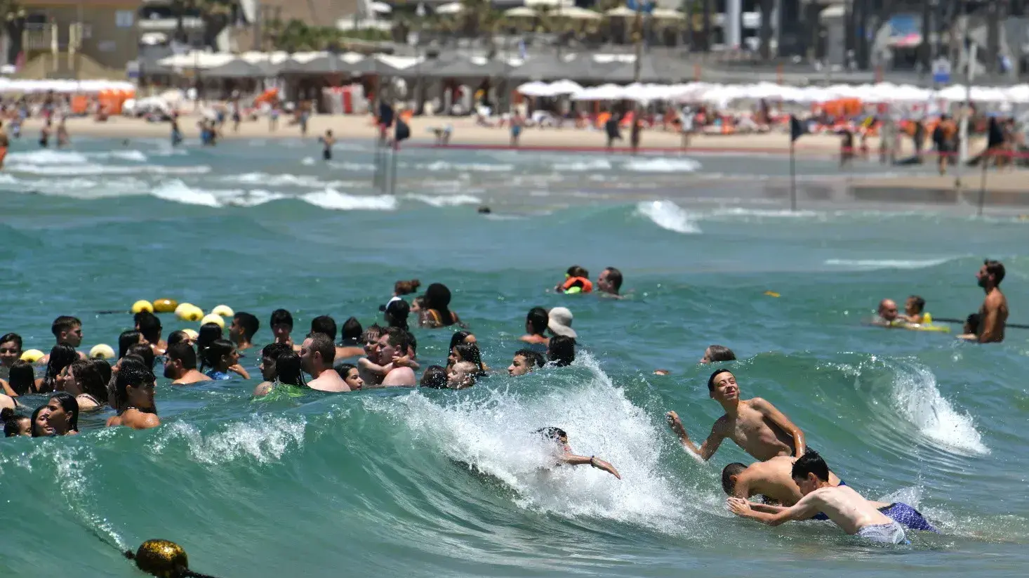 מתרחצים בחוף הים של תל אביב, 12 ביולי 2023