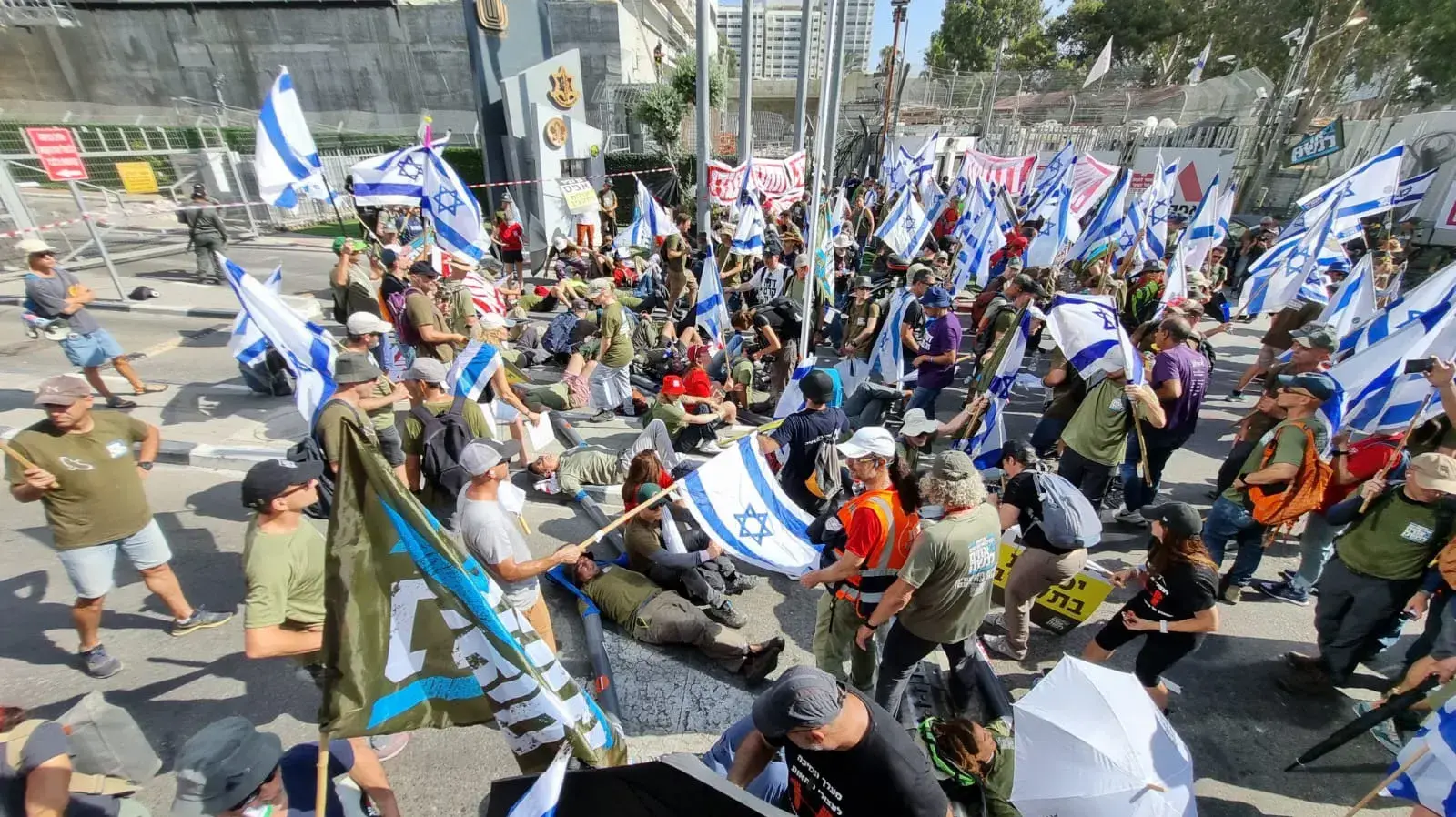 יום שיבושים: הפגנות נגד המהפכה המשפטית, אזוקים בשמש מול הכניסה לקריה. 18 ביולי 2023 יום שיבושים: הפגנות נגד המהפכה המשפטית, אזוקים בשמש מול הכניסה לקריה. 18 ביולי 2023