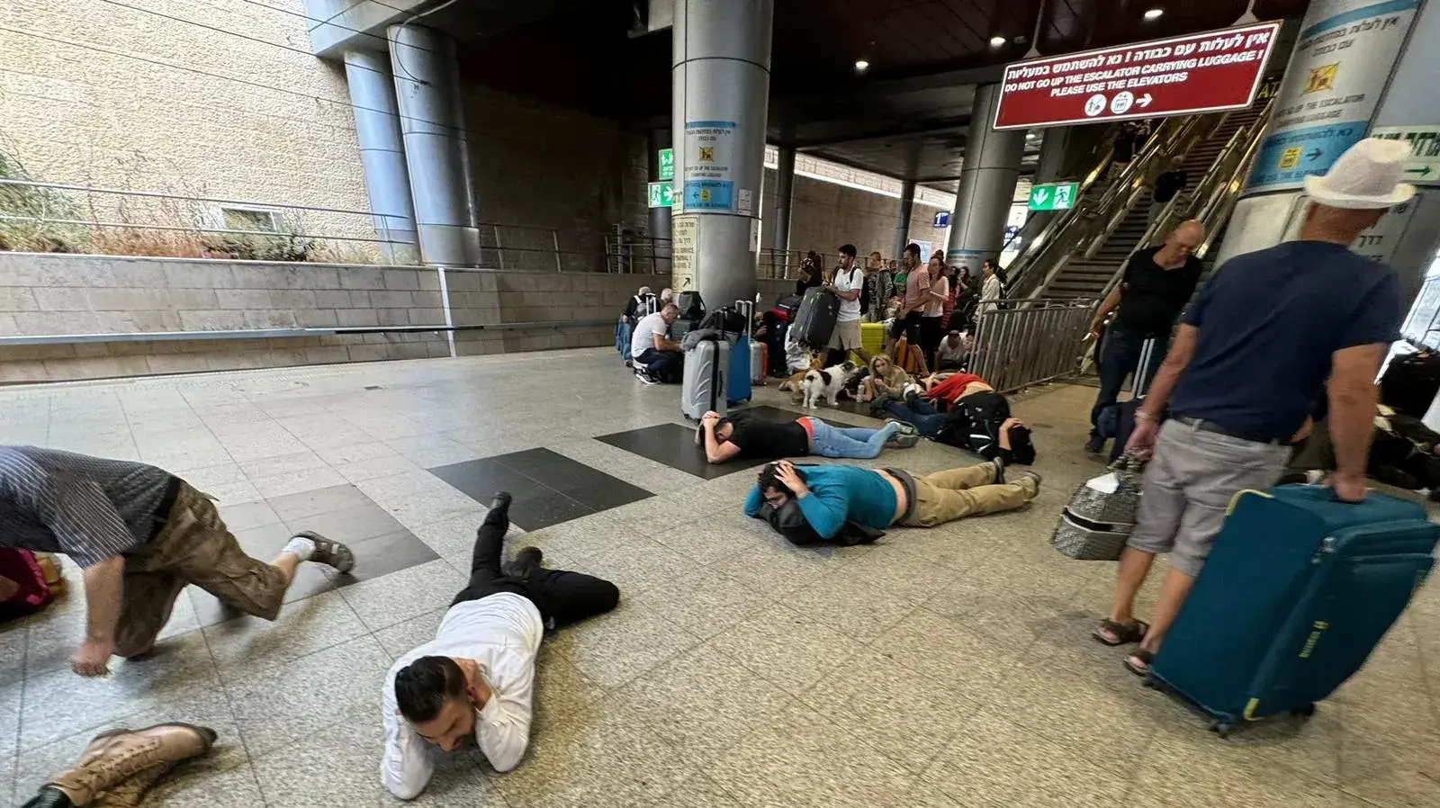 נוסעים בתחנת הרכבת שוכבים על הרצפה בעת אזעקה, נתב"ג, 9 באוקטובר 2023 נוסעים בתחנת הרכבת שוכבים על הרצפה בעת אזעקה, נתב"ג, 9 באוקטובר 2023