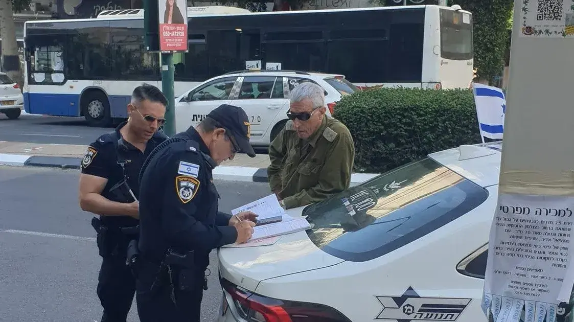 שוטרי תנועה נותנים דו"ח תנועה לקצין מילואים בגבעתיים