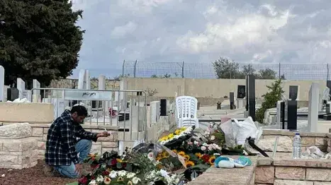 נבו, בן זוגה של עדי ברוך, על הקבר שלה עם טבעת הנישואין. 