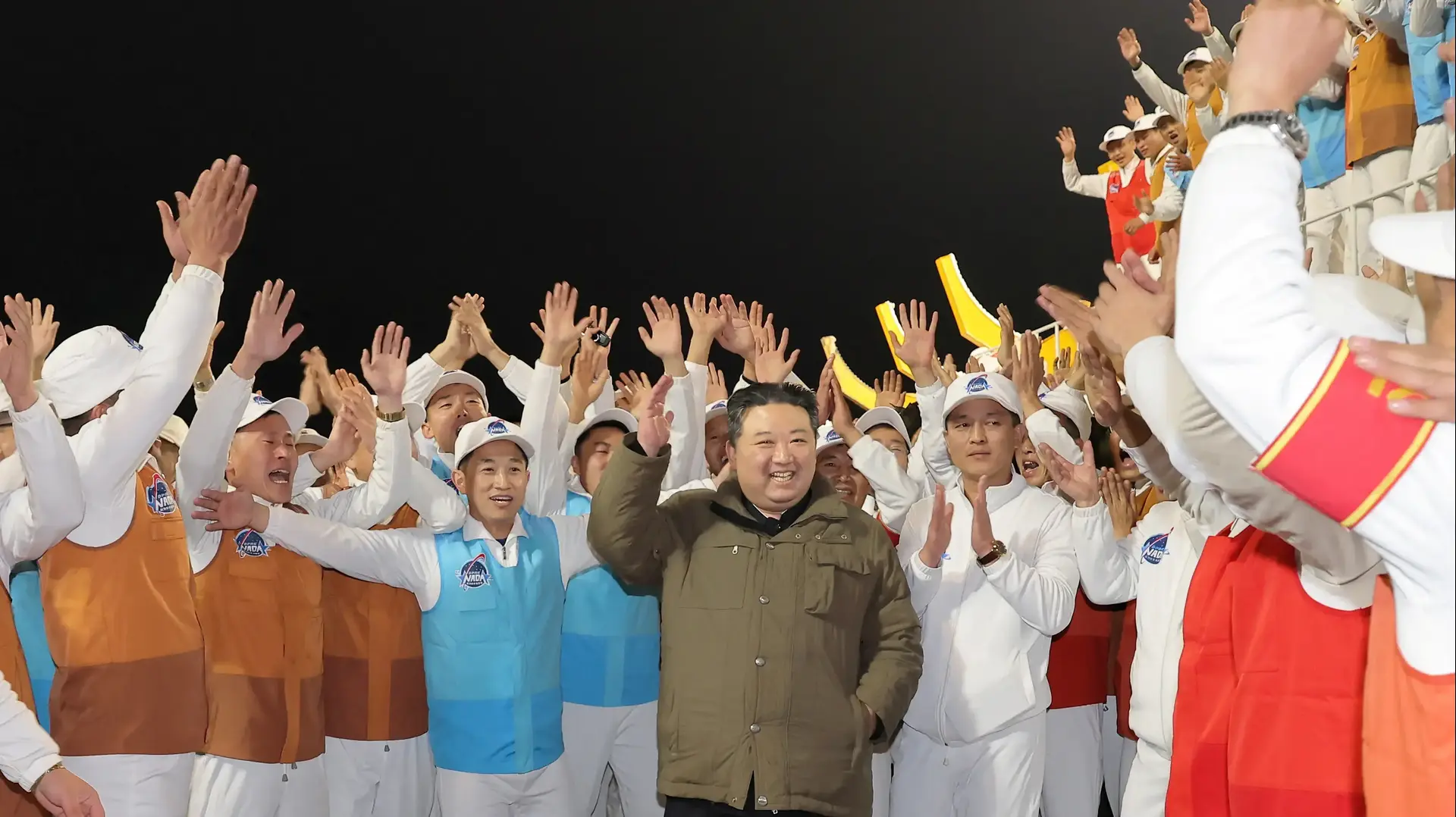מנהיג קוריאה הצפונית קים ג'ונג און חוגג עם עובדי תעשיית החלל אחרי שיגור לוויין, 21 בנובמבר 2023 מנהיג קוריאה הצפונית קים ג'ונג און חוגג עם עובדי תעשיית החלל אחרי שיגור לוויין, 21 בנובמבר 2023