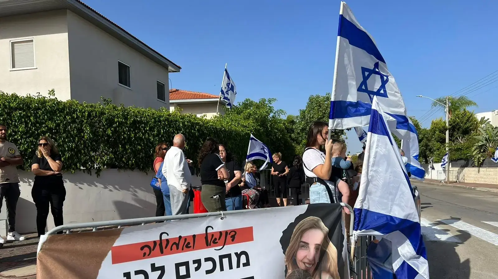 תושבי יבנה ליד ביתן של דניאל ואמיליה אלוני ששבו משבי חמאס, 26 בנובמבר 2023 תושבי יבנה ליד ביתן של דניאל ואמיליה אלוני ששבו משבי חמאס, 26 בנובמבר 2023