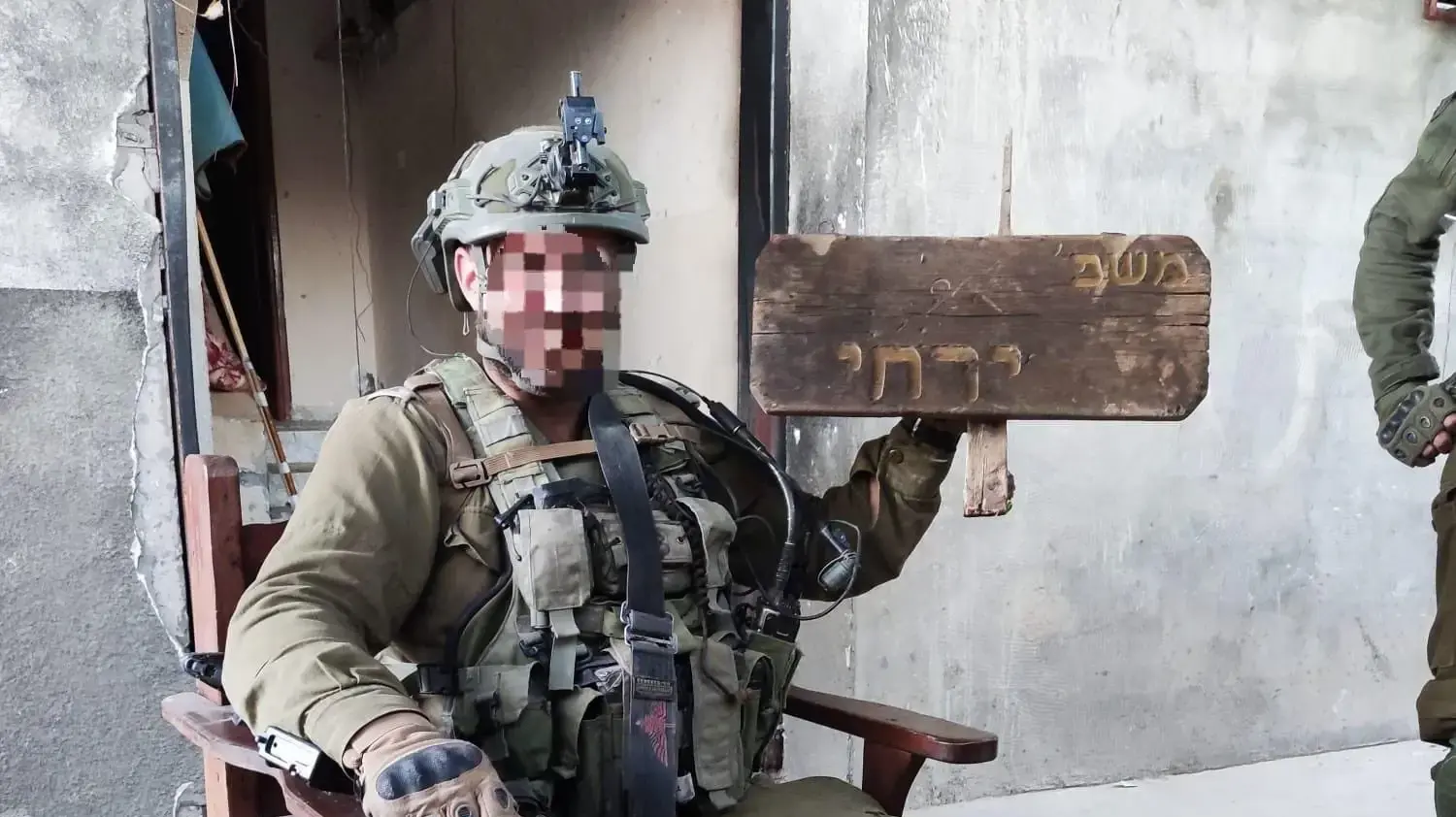 חייל מחזיק בשלט של משפחת ירחי ברצועת עזה חייל מחזיק בשלט של משפחת ירחי ברצועת עזה