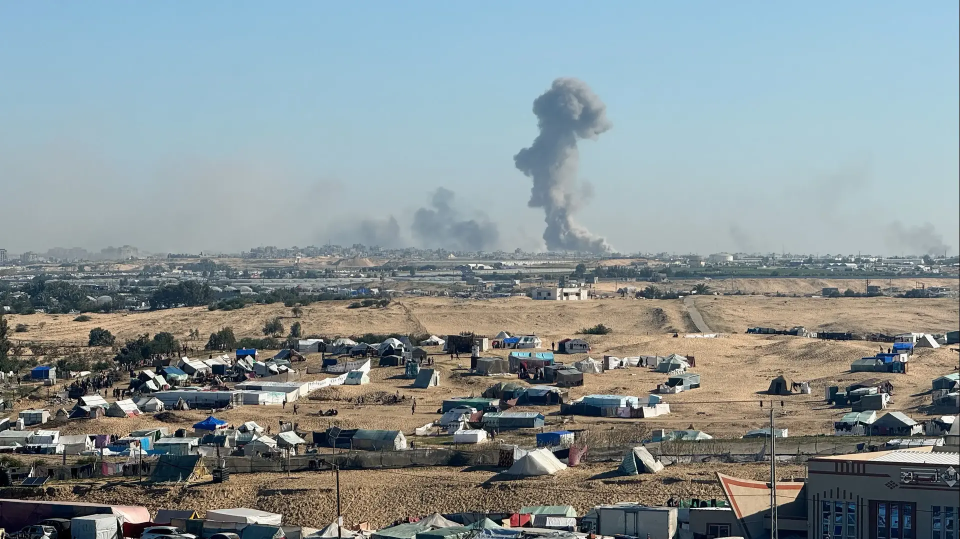 עשן מיתמר מהעיר חאן יונס כפי שנראה ממחנה אוהלים בעיר רפיח שבדרום רצועת עזה, 11 בפברואר 2024