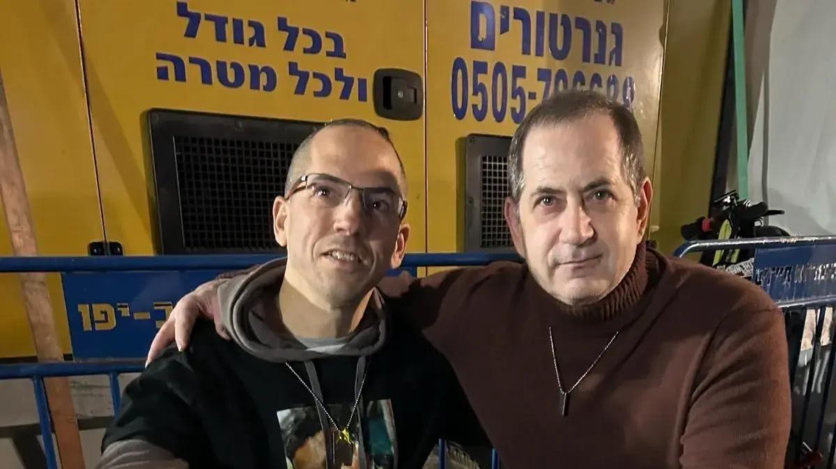 מייסד פרס בראשית סטן פולובץ (מימין) עם דורון זקצר, המחזיק בתמונה של עידן אלכסנדר, אותו אירח בביתו בישראל כחייל בודד