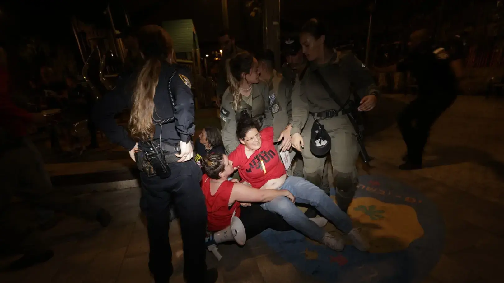 שוטרים גוררים את כלתו של החטוף יותם מצגר בהפגנת לפידים סמוך למעון ראש הממשלה 02 באפריל 2024 שוטרים גוררים את כלתו של החטוף יותם מצגר בהפגנת לפידים סמוך למעון ראש הממשלה 02 באפריל 2024