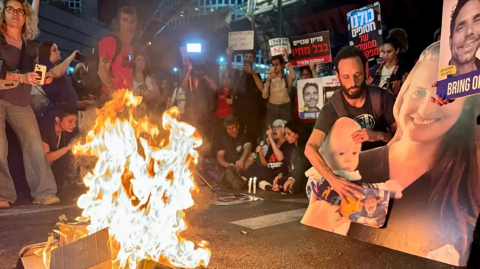 מדורה מול שער בגין, ראומה קדם ועינב צנגאוקר יושבות על הכביש ונואמות מדורה מול שער בגין, ראומה קדם ועינב צנגאוקר יושבות על הכביש ונואמות