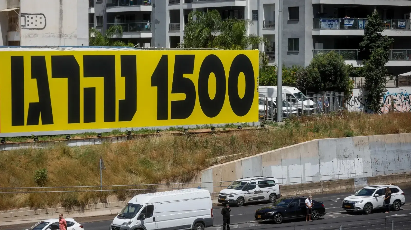 אנשים עומדים בצפירת יום הזיכרון, נתיבי איילון, 13 במאי 2024