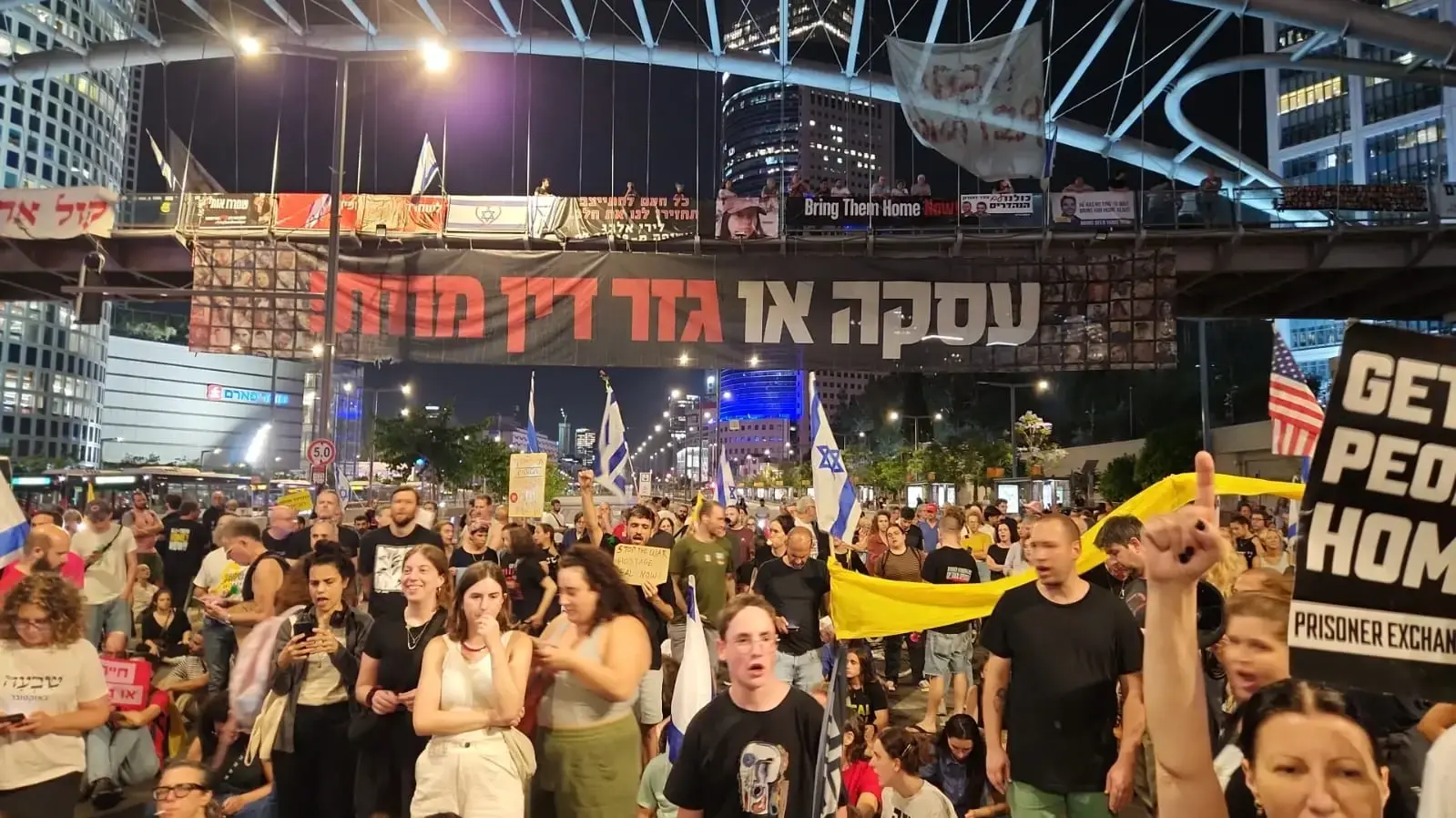 מפגינים חוסמים את דרך בגין לכיוון דרום מחוץ לבסיס הקרייה בתל אביב במחאה על מותם של החטופים