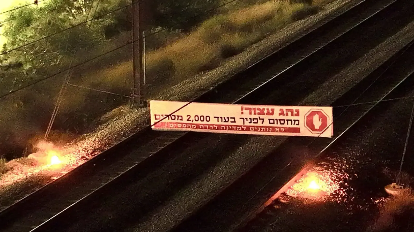 פעילי מחאה פרסו שלט שחסם את מסילת הרכבת בין אשדוד ליבנה בקריאה לבחירות, 16 ביוני 2024 פעילי מחאה פרסו שלט שחסם את מסילת הרכבת בין אשדוד ליבנה בקריאה לבחירות, 16 ביוני 2024