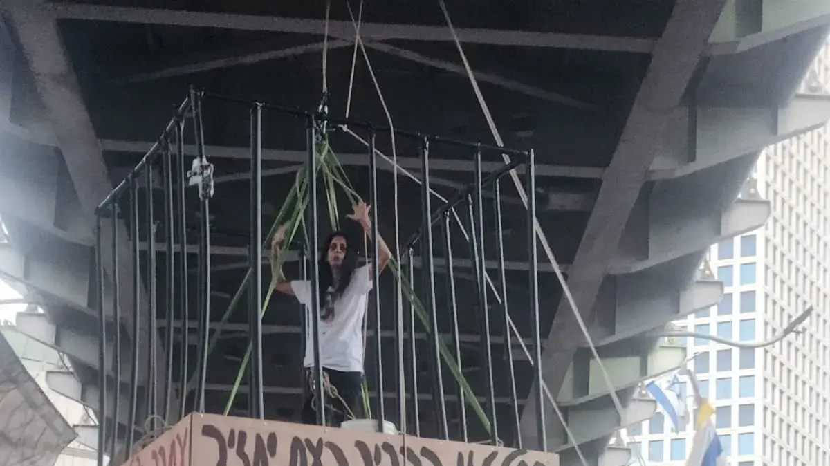 עינב צנגאוקר ב"כלוב" מתחת לגשר בגין בתל אביב, במחאה לשחרור החטופים עינב צנגאוקר ב"כלוב" מתחת לגשר בגין בתל אביב, במחאה לשחרור החטופים