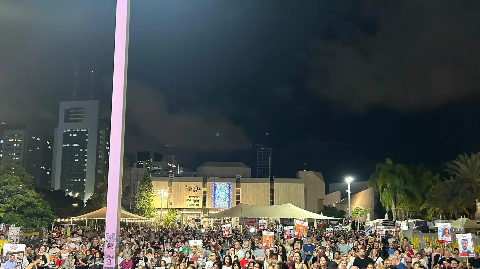 המוני אנשים בכיכר החטופים  בהקרנת נאום רה״מ ונאומי משפחות החטופים תחת המסר ״עסקה או הפקרה״.