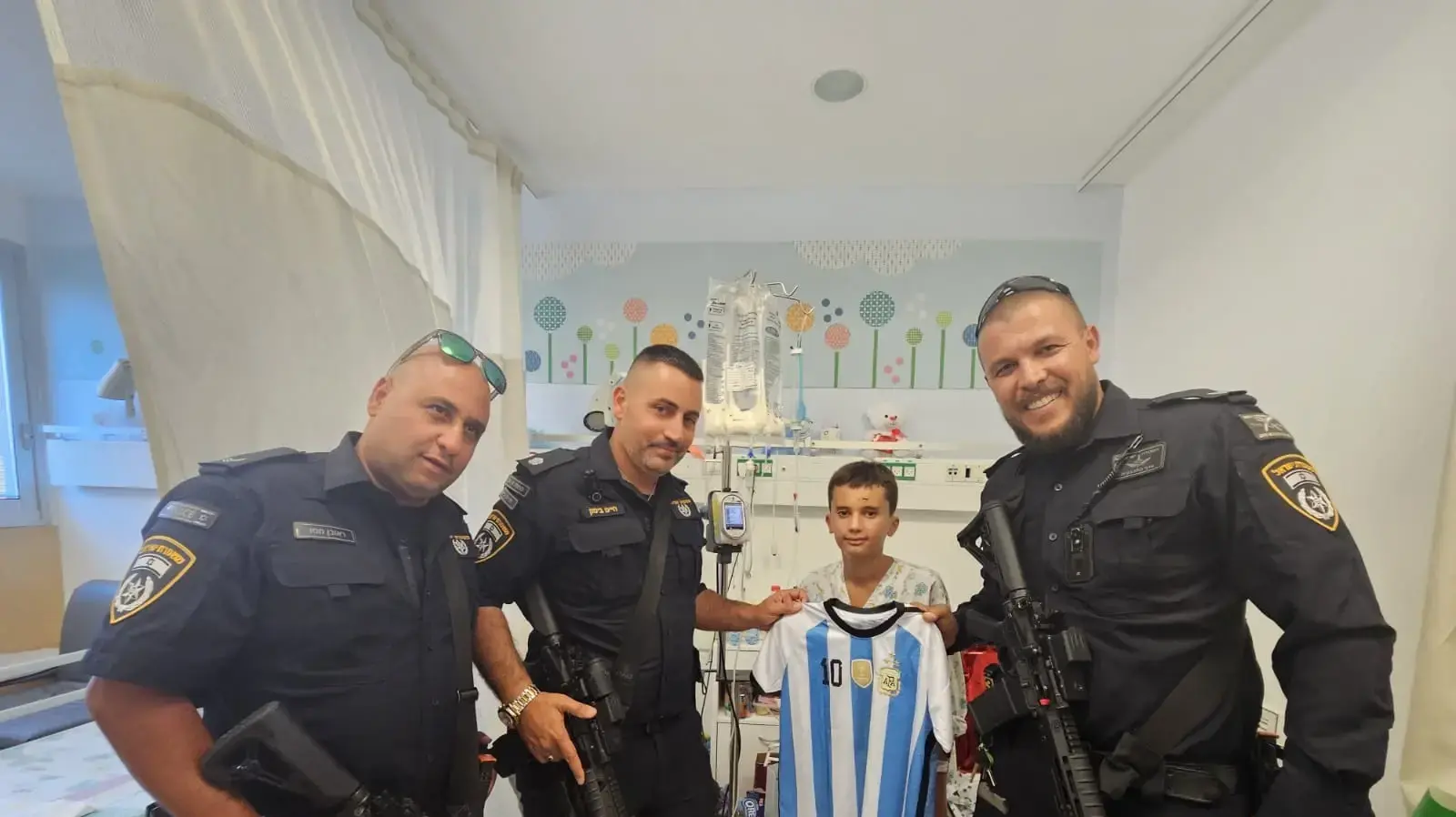 שוטרי משטרת ישראל בביקור אצל הילדים שנפגעו מפגיעת הרקטה במג'דל שמס בבית החולים זיו בצפת