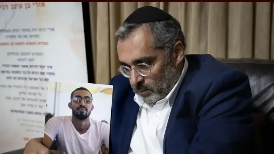 אלחנן דנינו עם תמונת בנו, אורי דנינו.
אלחנן דנינו עם תמונת בנו, אורי דנינו.