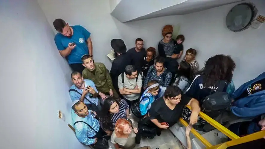 אנשים תופסים מחסה בעת אזעקה לאחר ירי טילים מאיראן,מקלט בתחנת רכבת נתב"ג, 1 באוקטובר 2024
