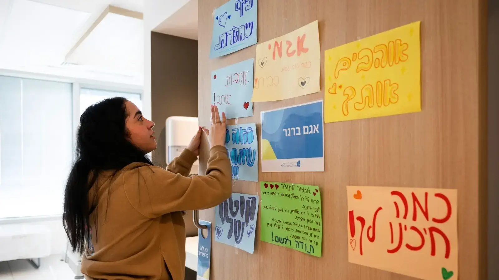 ארבע התצפיתניות - דניאלה, לירי, נעמה וקרינה - ששבו לארץ בשבת האחרונה, ממתינות לחברתן אגם והכינו שלטים לקראת הגעתה לבית החולים