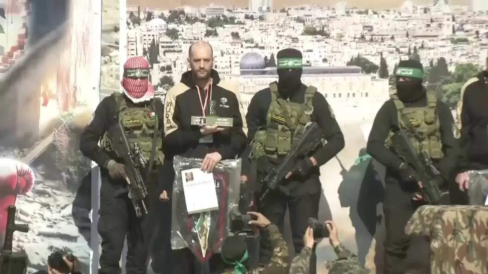 יאיר הורן מחזיק את המיצג של שעון חול עם תמונותיהם של עינב ומתן צנגאוקר עם הכיתוב "הזמן אוזל"