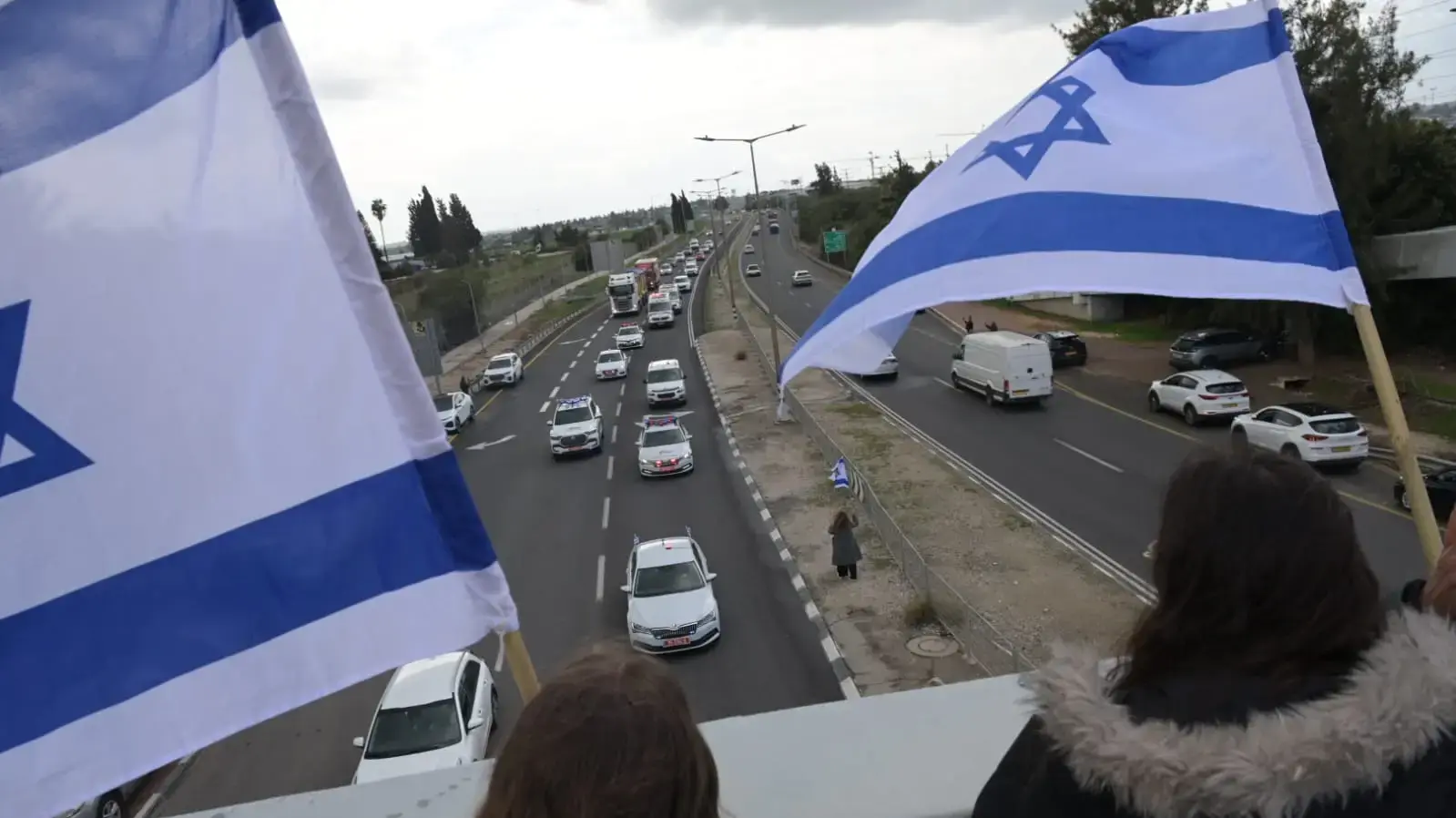 קהל ממתין לשיירת ארונות החללים החטופים בדרכה לאבו כביר, צומת אשקלון, 20 בפברואר 2025 קהל ממתין לשיירת ארונות החללים החטופים בדרכה לאבו כביר, צומת אשקלון, 20 בפברואר 2025