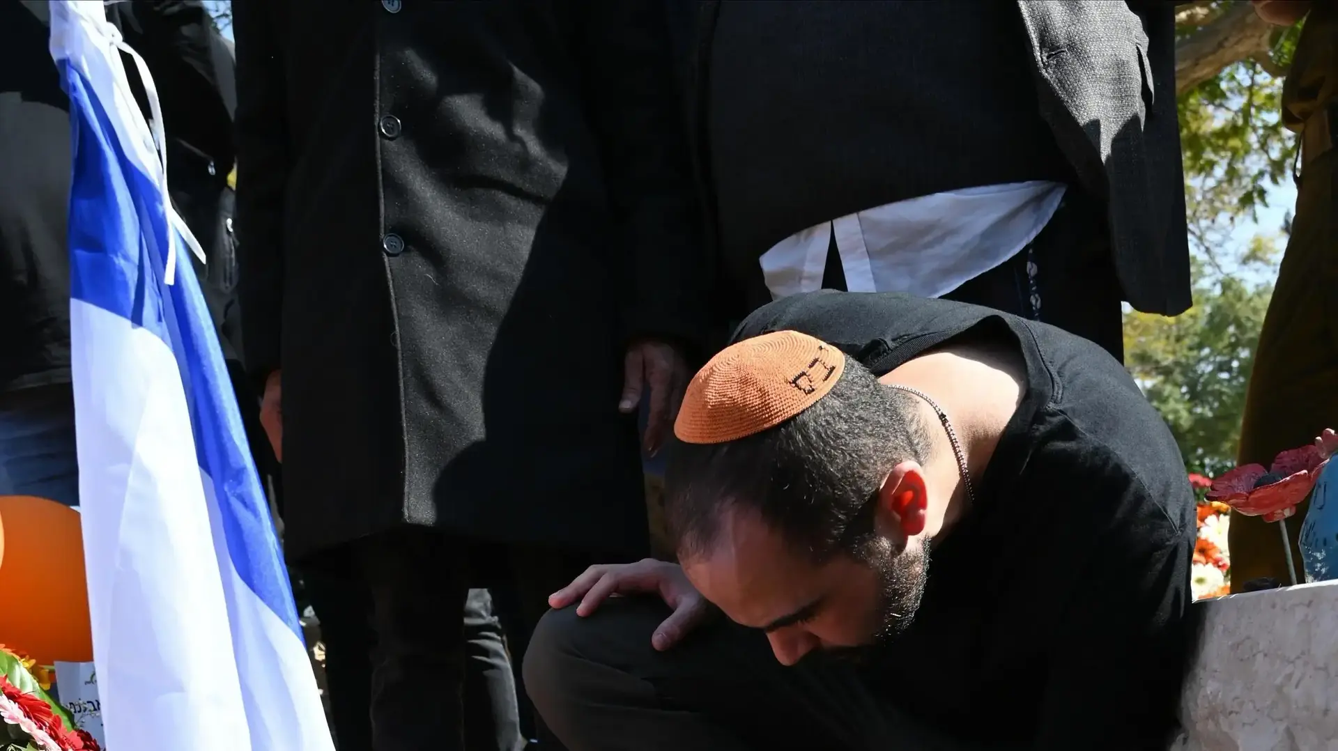 ירדן ביבס מדליק נר זיכרון לזכרם של אשתו וילדיו, בית העלמין בישוב צחר, 26 בפברואר 2025