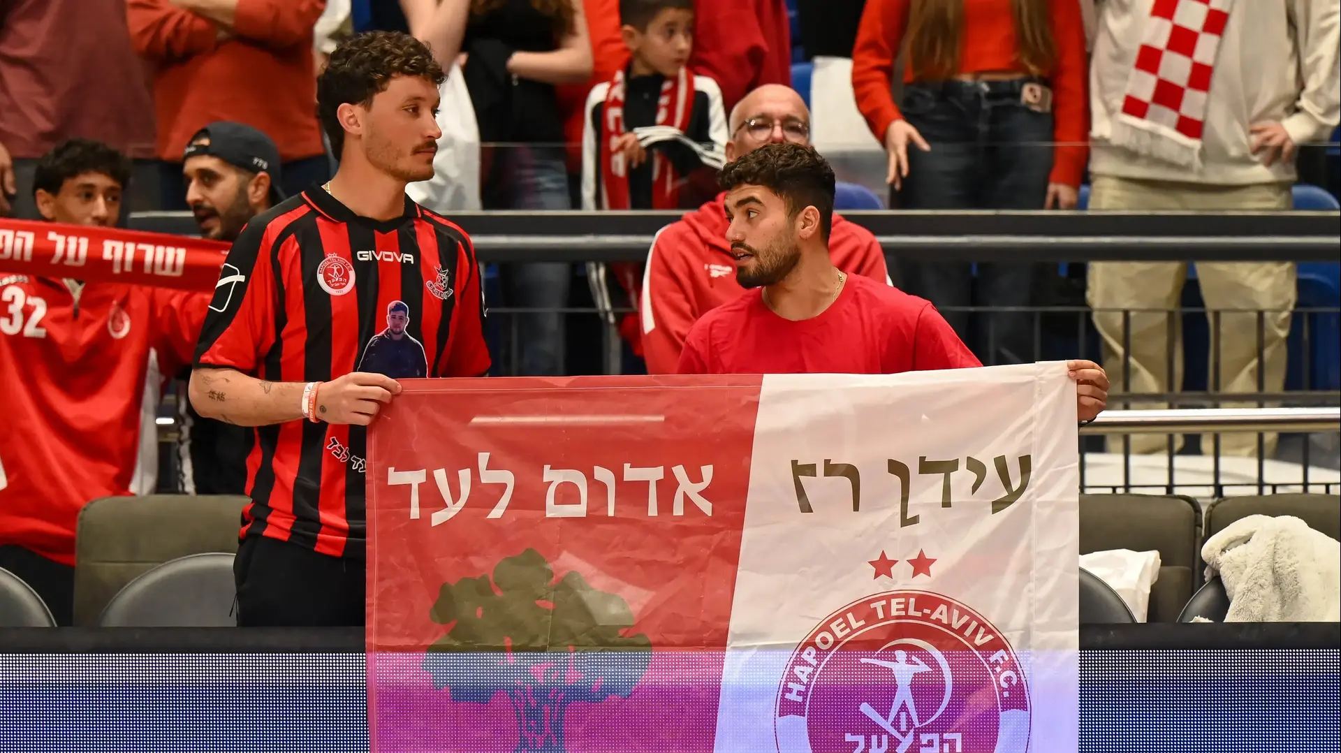 אוהדי הפועל תל אביב עם דגל לזכר עידן רז ז"ל