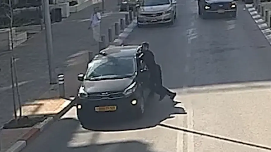 תיעוד הנסיעה בזמן שגופו של השוטר תלוי על הרכב