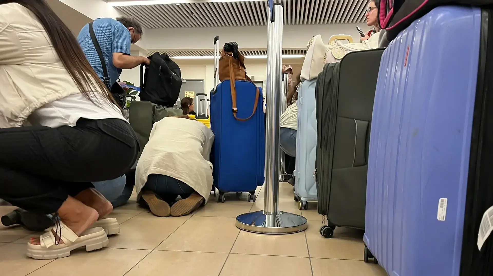אנשים תופסים מחסה בזמן אזעקה בשל שיגור טילים מתימן, נתב"ג, 4 במאי 2025 אנשים תופסים מחסה בזמן אזעקה בשל שיגור טילים מתימן, נתב"ג, 4 במאי 2025