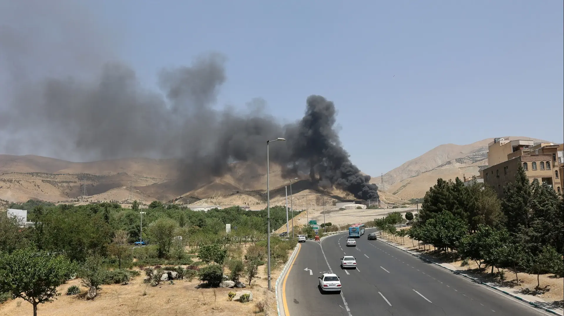 מכוניות חולפות על פני עשן המיתמר מטהראן, איראן, 16 ביוני 2025 מכוניות חולפות על פני עשן המיתמר מטהראן, איראן, 16 ביוני 2025
