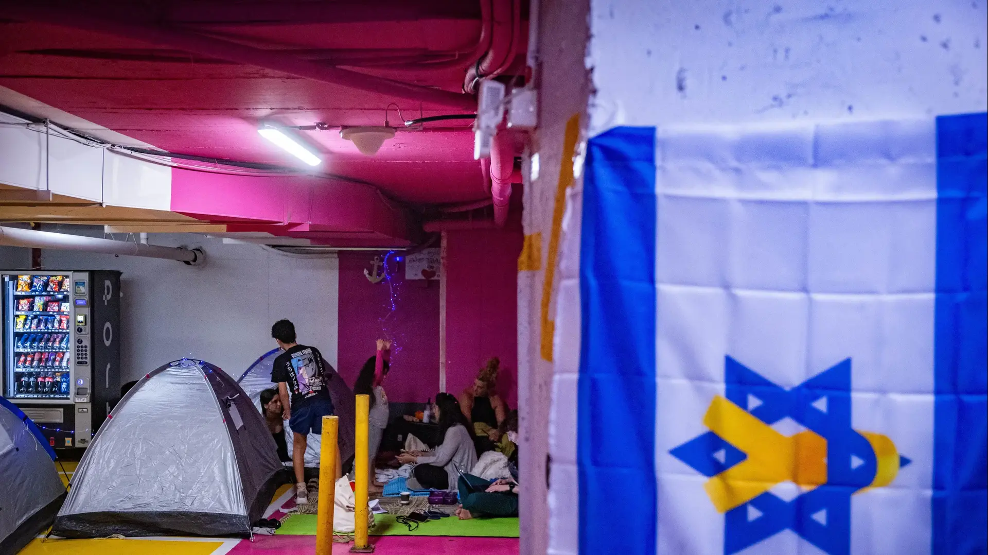 אנשים תופסים מחסה בחניון שהפך מקלט ציבורי, חניון דיזנגוף סנטר, 17 ביוני 2025 אנשים תופסים מחסה בחניון שהפך מקלט ציבורי, חניון דיזנגוף סנטר, 17 ביוני 2025