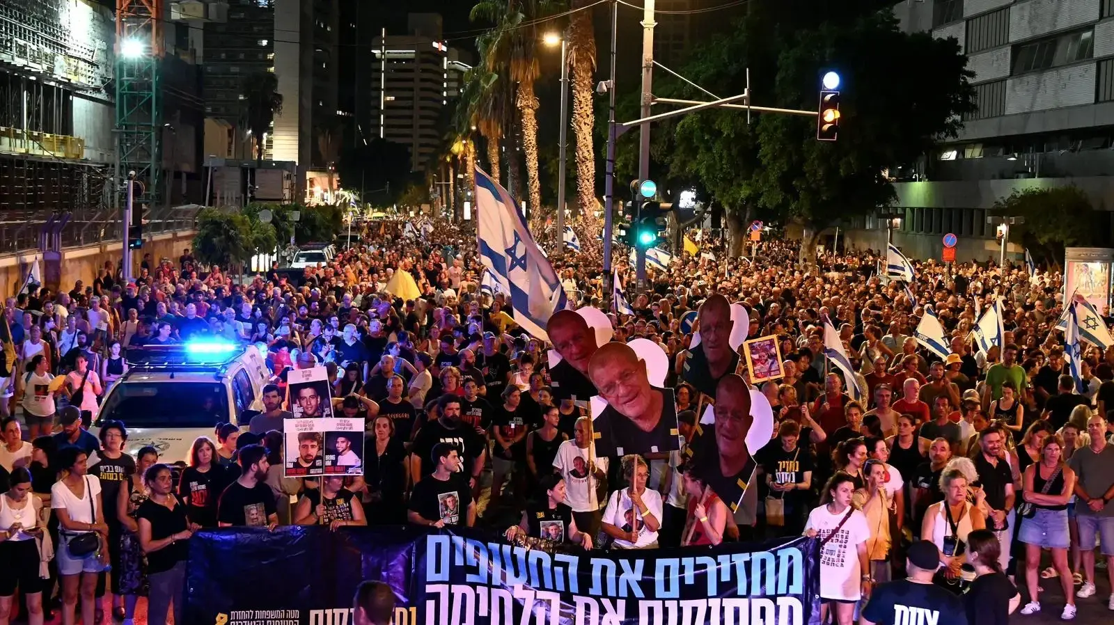 מפגינים לצד משפחות החטופים והחטופה מסביב לבסיס הקריה