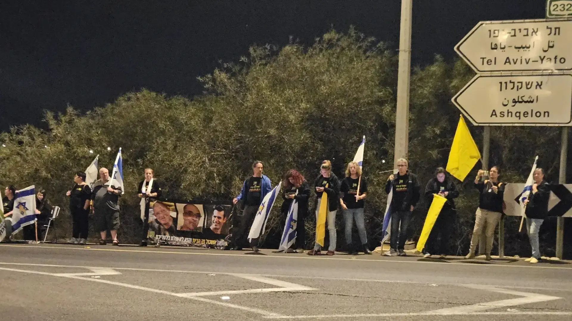 עשרות בני אדם מחכים לשיירה הנושאת ארון של חלל חטוף בצומת תל גמה עשרות בני אדם מחכים לשיירה הנושאת ארון של חלל חטוף בצומת תל גמה