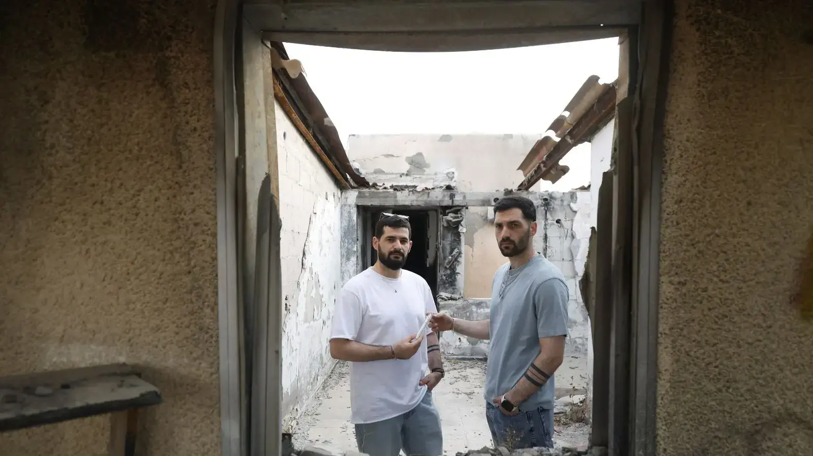 שורדי השבי גלי וזיו ברמן לוקחים את המזוזה מהבית השרוף ממנו נחטפו בקיבוץ כפר עזה