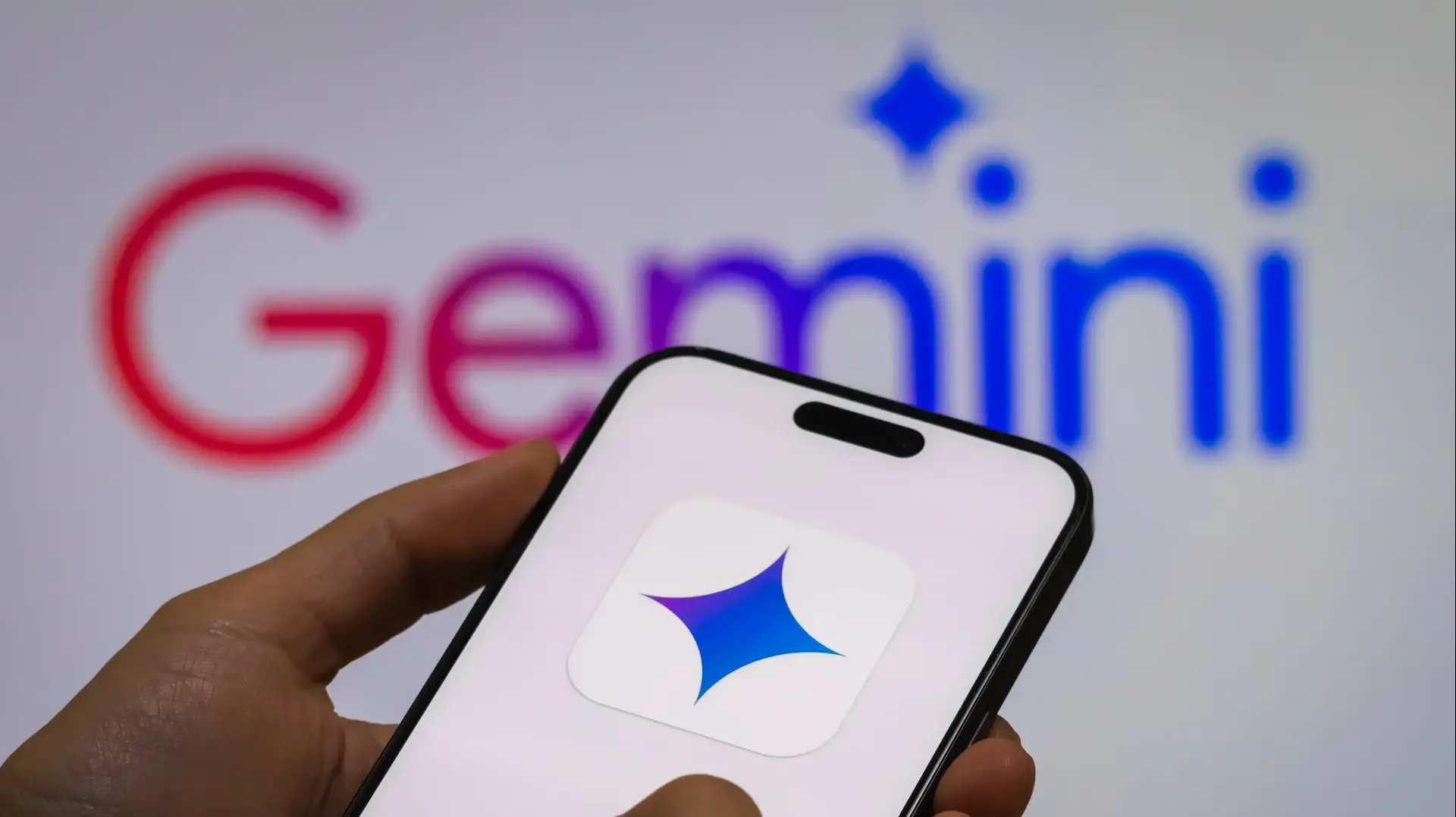 Человек держит смартфон с логотипом Gemini, модели искусственного интеллекта нового поколения от Google Человек держит смартфон с логотипом Gemini, модели искусственного интеллекта нового поколения от Google