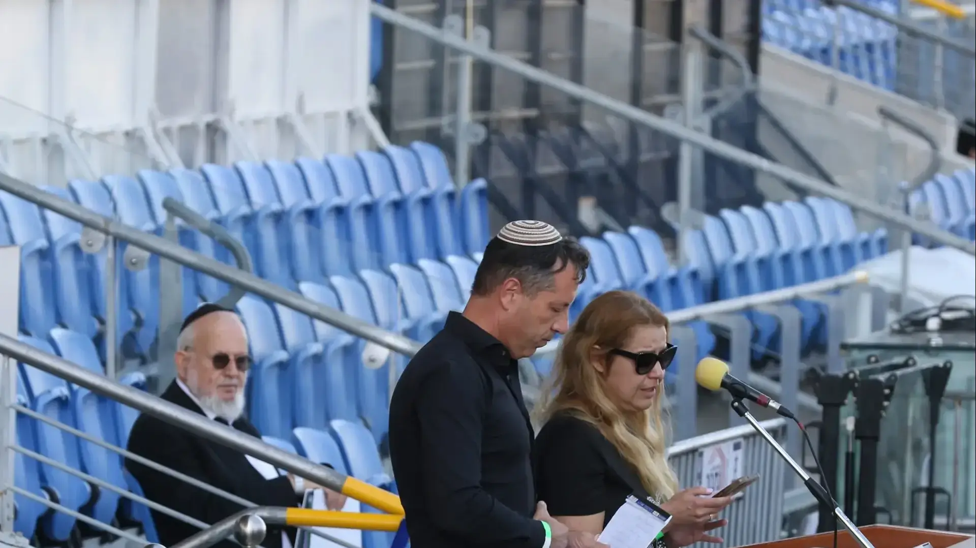 בנה ובתה של מרים פיירברג, בהלווית אמם, אצטדיון נתניה, 23 בנובמבר 2025 בנה ובתה של מרים פיירברג, בהלווית אמם, אצטדיון נתניה, 23 בנובמבר 2025