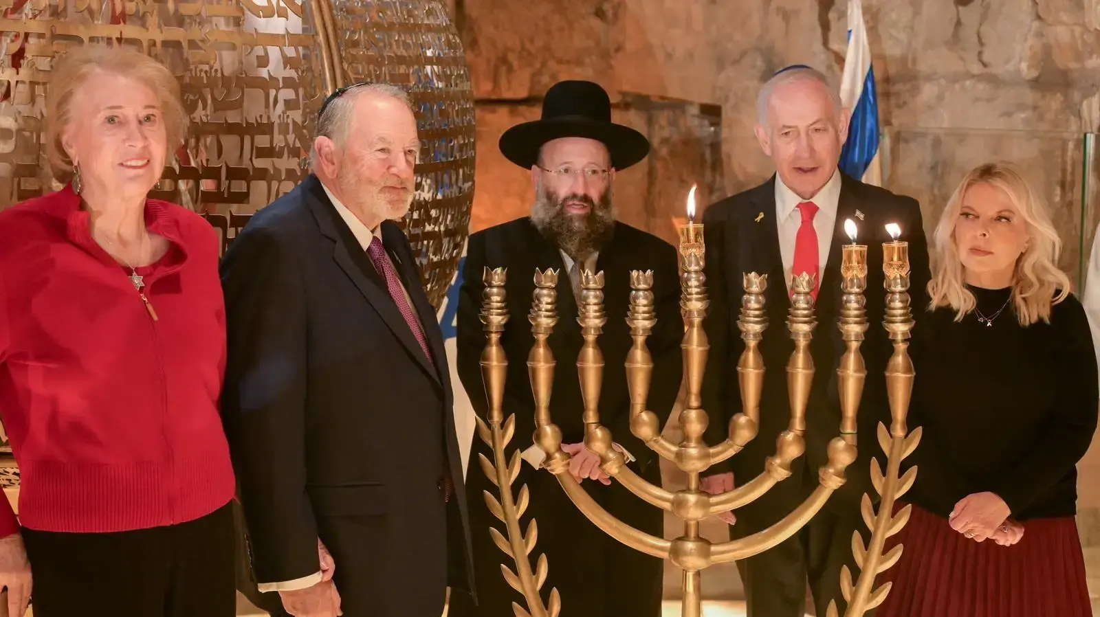ראש הממשלה בנימין נתניהו ורעייתו שרה נתניהו הדליקו נר שני של חנוכה יחד עם לוחמי צה״ל, רב הכותל והממונה על המקומות הקדושים, הרב שמואל רבינוביץ׳ ורעייתו, מנכ״ל מורשת הכותל מרדכי (סולי) אליאב ושגריר ארה״ב מייק האקבי ורעייתו ג׳נט, הכותל, 15 בדצמבר 2025 ראש הממשלה בנימין נתניהו ורעייתו שרה נתניהו הדליקו נר שני של חנוכה יחד עם לוחמי צה״ל, רב הכותל והממונה על המקומות הקדושים, הרב שמואל רבינוביץ׳ ורעייתו, מנכ״ל מורשת הכותל מרדכי (סולי) אליאב ושגריר ארה״ב מייק האקבי ורעייתו ג׳נט, הכותל, 15 בדצמבר 2025