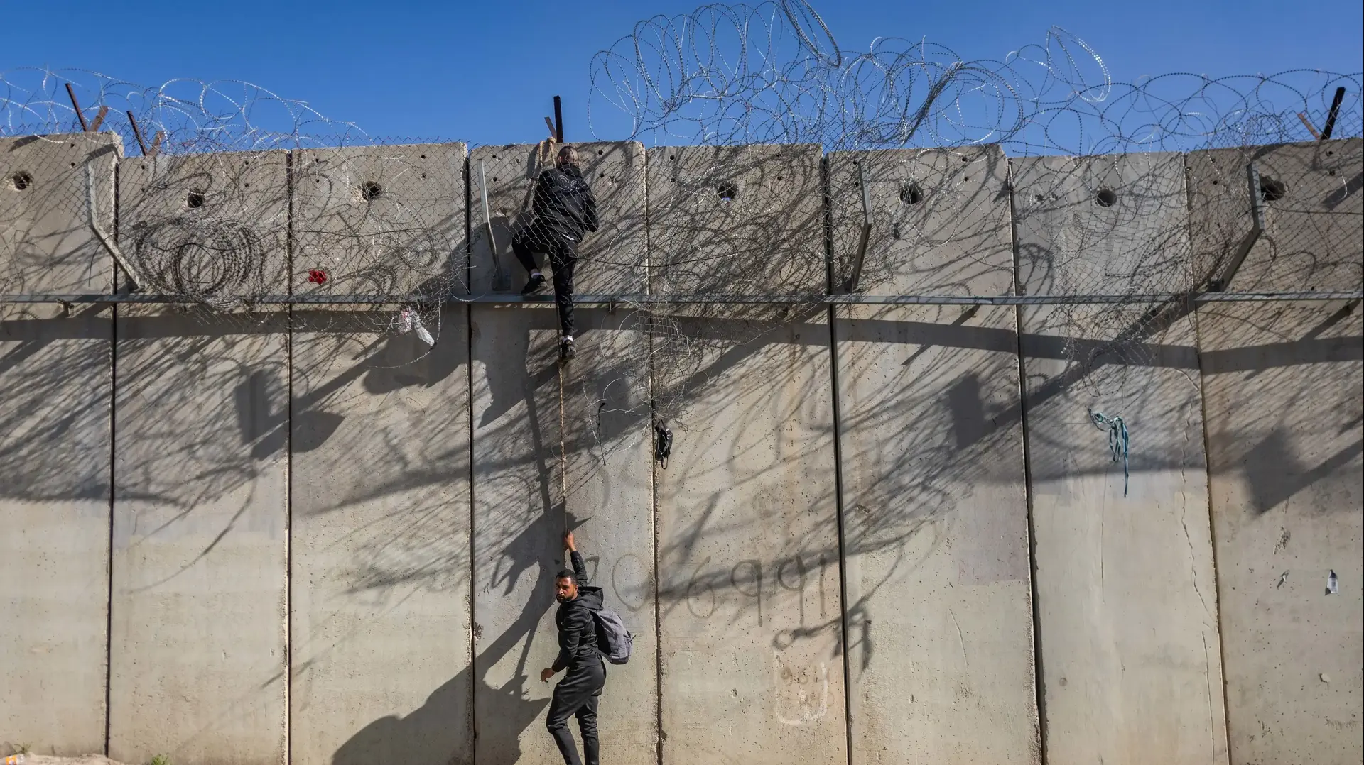 פלסטינים חוצים את גדר ההפרדה באמצעות חבל, סמוך לא-ראם, 23 בדצמבר 2025 פלסטינים חוצים את גדר ההפרדה באמצעות חבל, סמוך לא-ראם, 23 בדצמבר 2025