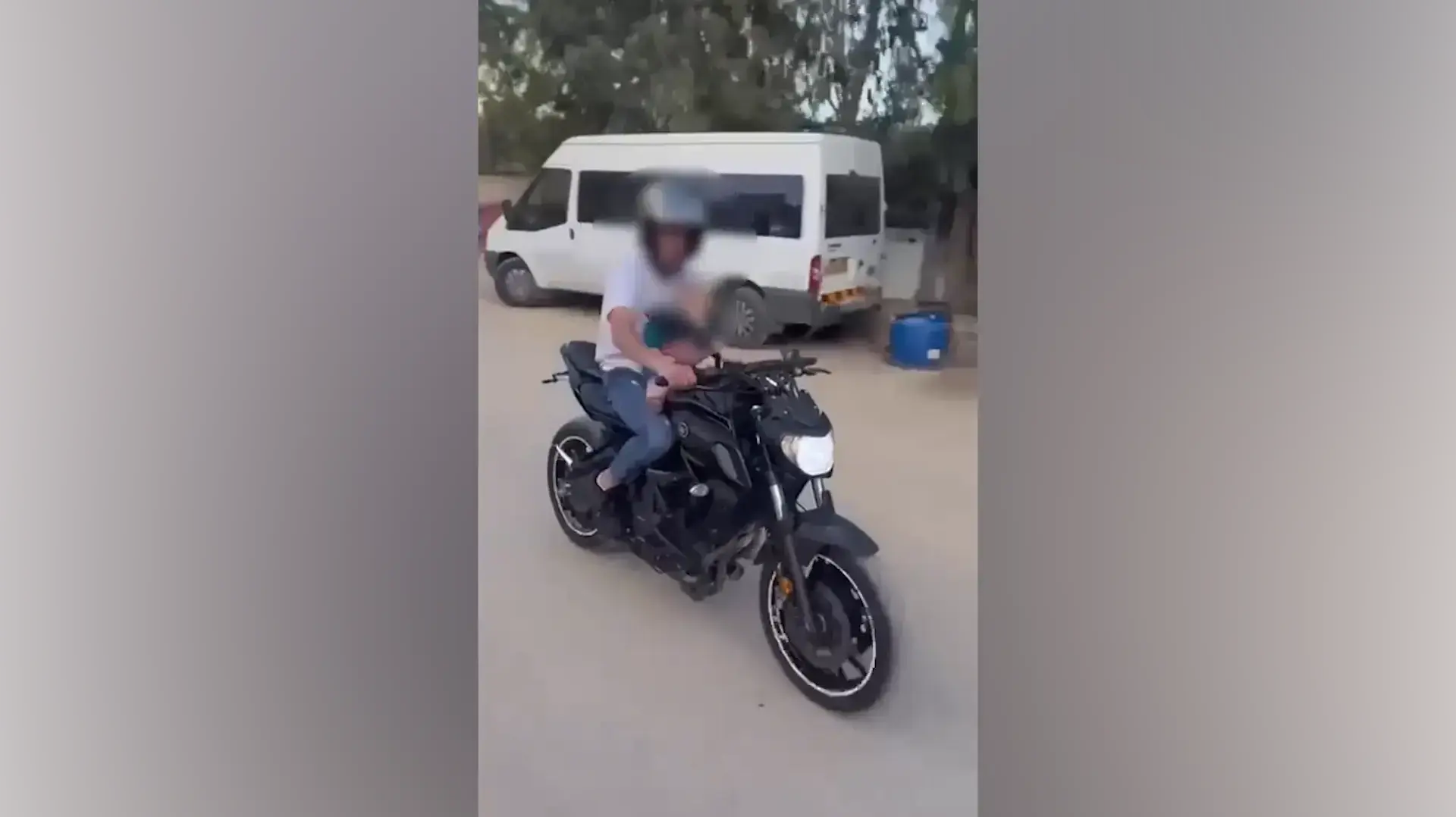 צעיר רוכב על אופנוע ומרכיב את אחיו התינוק כבן שנה