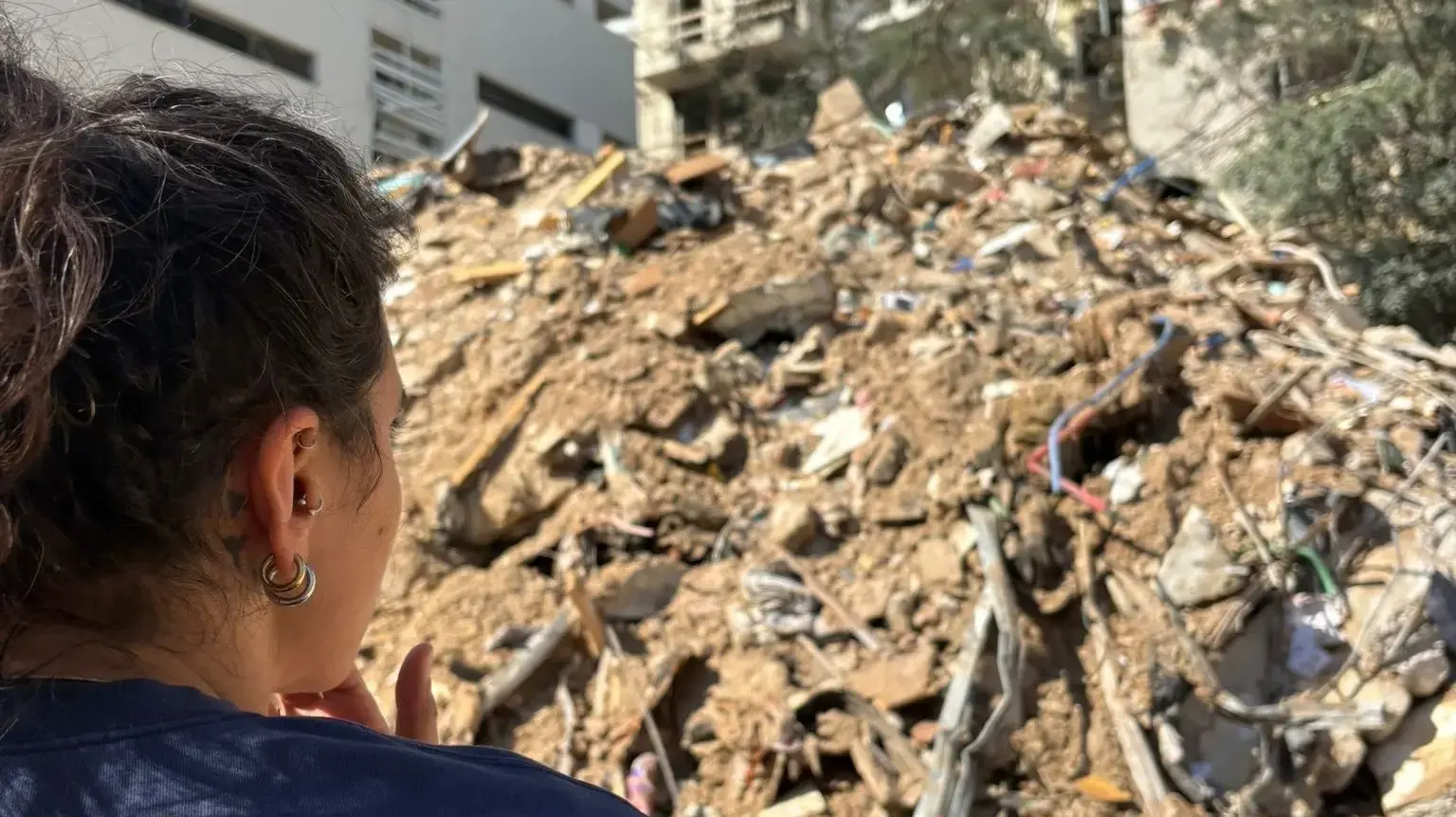 המוזיקאית תמר בלס מול מה שהיה ביתה והפך להריסות לאחר הפגיעה של טיל ששוגר מאיראן במרכז תל אביב ב-28 בפברואר 2026 המוזיקאית תמר בלס מול מה שהיה ביתה והפך להריסות לאחר הפגיעה של טיל ששוגר מאיראן במרכז תל אביב ב-28 בפברואר 2026