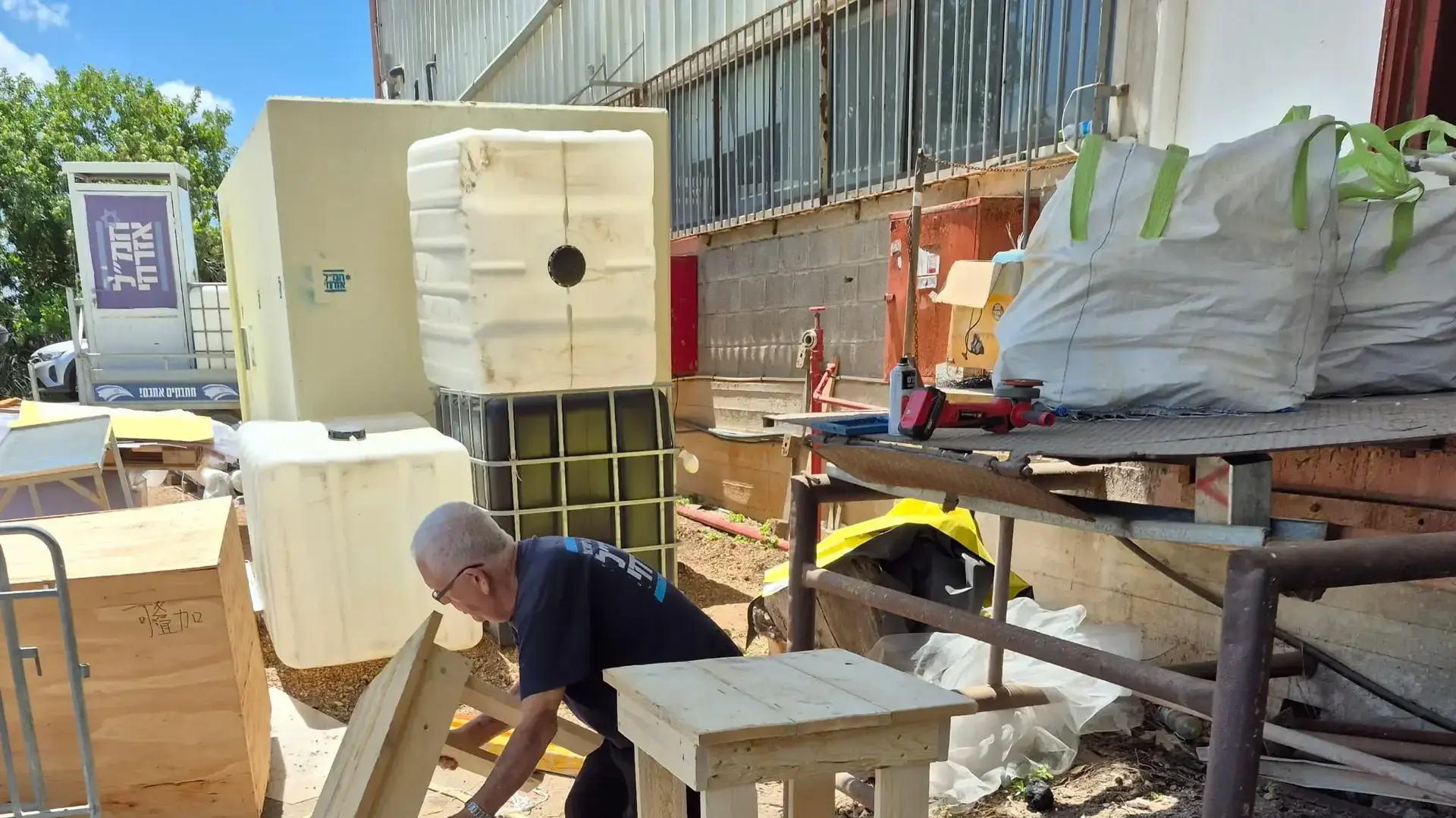 בני גלר, מתנדב בחמל אזרחי, עם שולחנות שבנו בנגריה בני גלר, מתנדב בחמל אזרחי, עם שולחנות שבנו בנגריה