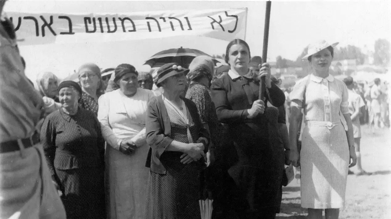 חיה רחל נחומובסקי-מילנר מחזיקה את הכרזה חיה רחל נחומובסקי-מילנר מחזיקה את הכרזה