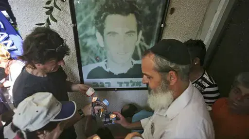 שכנים מדליקים נרות נשמה מחוץ לית משפחת רגב