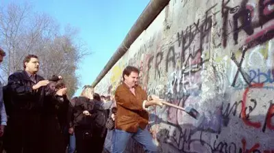 אדם מסייע בהפלת חומת ברלין