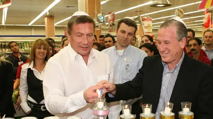 נוחי דנקנר ואפי רוזנהויז מדליקים נרות בסניף שופרסל בשדרות