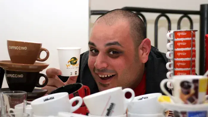 מאור גלאם עם אוסף מכונות וכוסות הקפה שלו.  