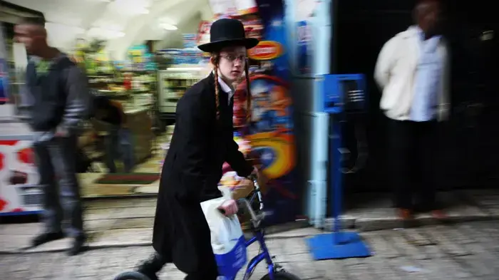 ילד חרדי נוסע על קורקינט