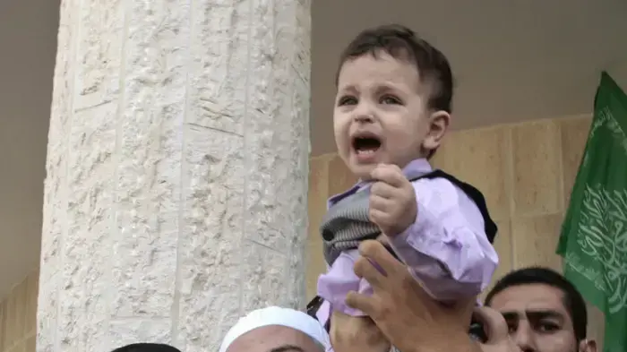 מנהיג חמאס הנייה מחזיק את בנה של האסירה הפלסטינאית המשוחררת פטימה יוניס