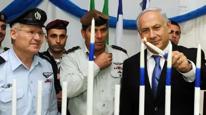 אש הממשלה בנימין נתניהו מדליק נר חנוכה עם חיילי צה"ל, הרמטכ"ל וראש אמ"ו