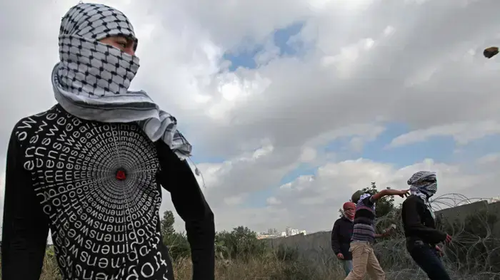 צעיר פלסטיני משליך אבן על כוח צה''ל בזמן הפגנה נגד בניית גדר ההפרדה סמוך לכפר ניעלין בשומרון