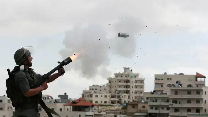 חייל מג"ב ישראלי יורה גז מדמיע לעבר פלסטינים במזרח ירושלים